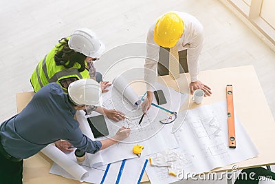 Team of engineers and architects working, planing, measuring layout of building blueprints in construction site. top view Stock Photo