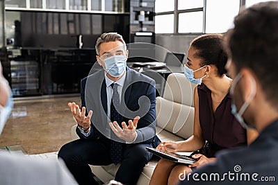 Business people talking in meeting with face mask Stock Photo