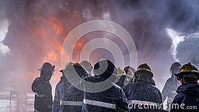 Team of fire fighters was trained to extinguishing huge flame with water hydrant Stock Photo