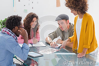 Team going over photo contact sheet Stock Photo