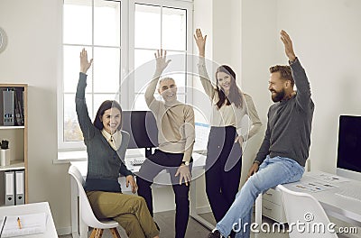 Team of happy, smiling employees voting for something during a corporate work meeting Stock Photo