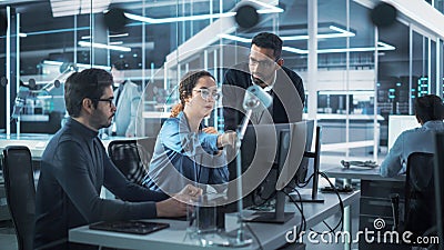 Team of Innovative Industrial Engineers Use Computer to Discuss a Technological Project in Industry Stock Photo