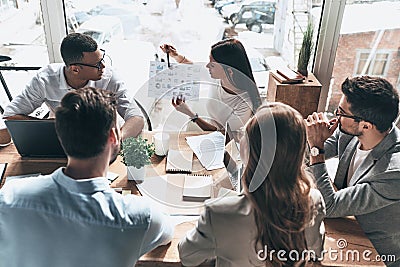 Team of innovators. Top view of young modern people in smart casual wear discussing business while working in the creative office Stock Photo