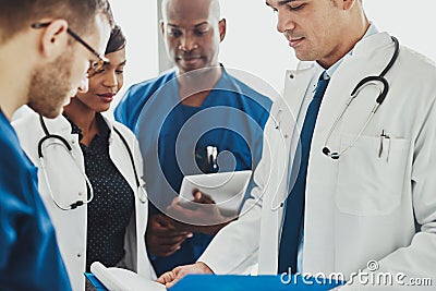 Team of multiracial doctors reading patient notes Stock Photo