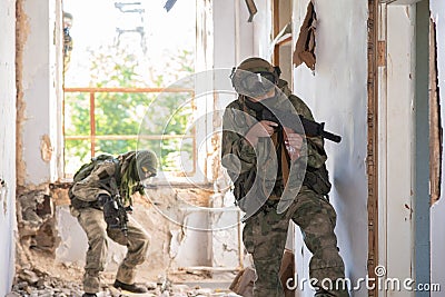 A team of professional airsoft players clear the location from opponents. Stock Photo