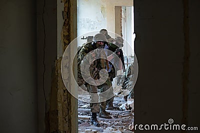 A team of professional airsoft players clear the location from opponents. Stock Photo