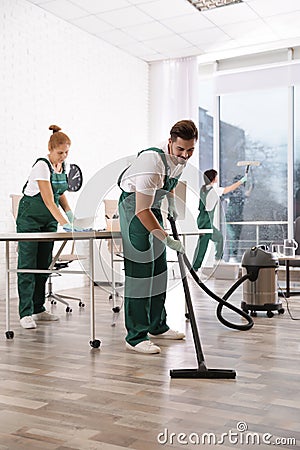 Team of professional janitors working in modern office. Stock Photo