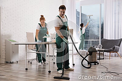 Team of professional janitors working in office. Cleaning service Stock Photo