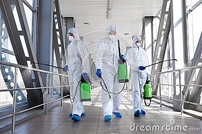 Team of professional virologists in protective suits ready for disinfection Stock Photo