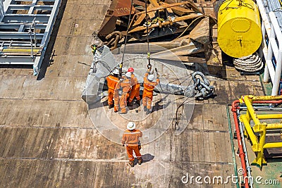 A team of rigger lifting an anchor from a construction work barge Editorial Stock Photo