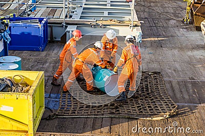 A team of riggers or roughnecks handling oil drum Editorial Stock Photo