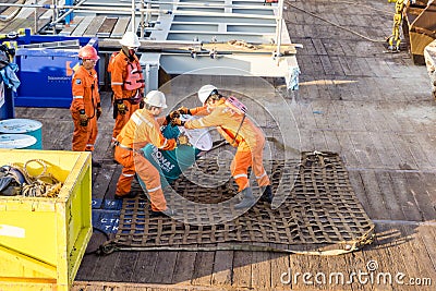 A team of riggers or roughnecks handling oil drum Editorial Stock Photo