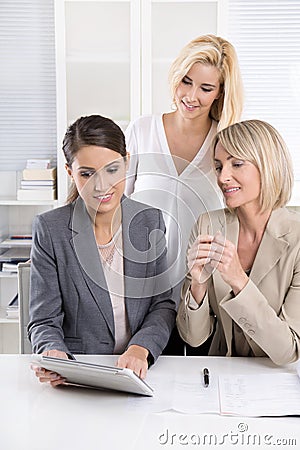 Team: Successful business team of woman in the office talking to Stock Photo