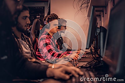 Team of teenage gamers plays in a multiplayer video game on pc in a gaming club. Stock Photo