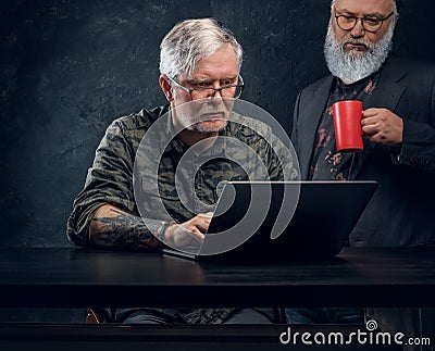 Team of two contemporary elderly men against dark background Stock Photo