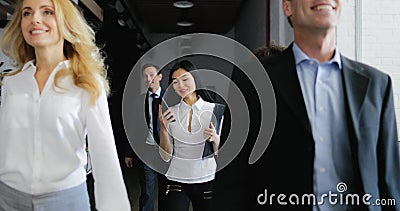 Team van bedrijfsmensen die in bureau lopen terwijl het Aziatische telefoongesprek van het onderneemsterantwoord stock footage Team van bedrijfsmensen die in bureau lopen terwijl het Aziatische telefoongesprek van het onderneemsterantwoord stock footage