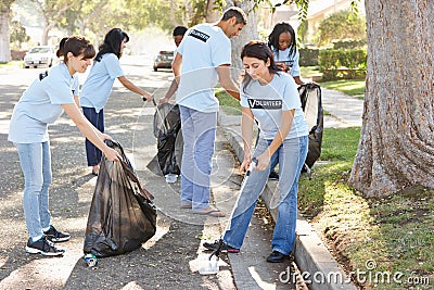 Team Of Volunteers Picking Up Litter In Suburban Street Stock Photo