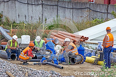 Workers at break and collect pipeline. Editorial Stock Photo
