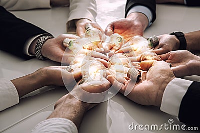 Teamwork and brainstorming concept with businessmen that share an idea with a lamp. Concept of startup Stock Photo