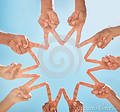 Teamwork, community and group support with fingers in a star shape from below against a blue sky background. A diverse Stock Photo