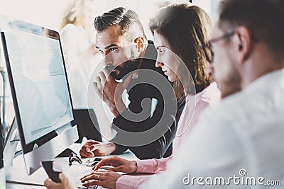 Teamwork concept.Young creative coworkers working with new startup project in modern office.Group of three people Stock Photo