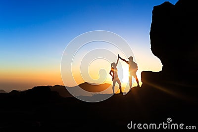 Teamwork couple climbing helping hand Stock Photo