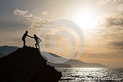 Teamwork couple climbing hiking with helping hand Stock Photo