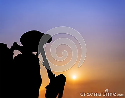 Teamwork couple helping hand trust assistance silhouette in mountains, sunset. Stock Photo