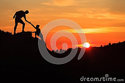 Teamwork couple helping hand trust in inspiring mountains Stock Photo