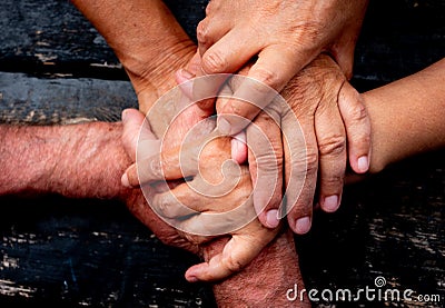 Teamwork and friendship concept.Five caucasian hands touching themself confirming the bonding. Black wood table on background Stock Photo