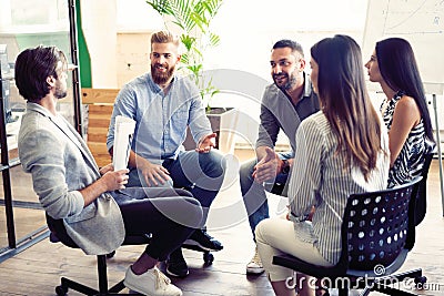 Teamwork is a key to success. Business people in smart casual wear talking and smiling while having a brainstorm meeting Stock Photo