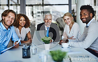 Teamwork makes their meetings work. Portrait of a team of professionals having a meeting in the boardroom at work. Stock Photo