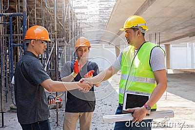 Teamwork, partnership, gesture concept. Builders greeting each other with handshake on construction site. construction workers in Stock Photo