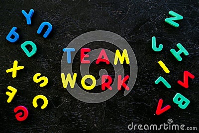 Teamwork training concept. Text teamwork lined with colored letters near toy letters on black background top view space Stock Photo