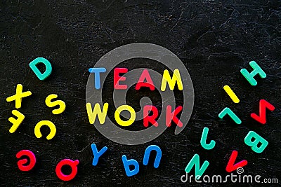 Teamwork training concept. Text teamwork lined with colored letters near toy letters on black background top view space Stock Photo