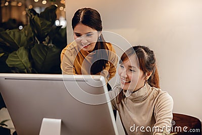 Teamwork, Working Together. Smiling Two Business Woman Workigng on Computer in Modern Office Stock Photo