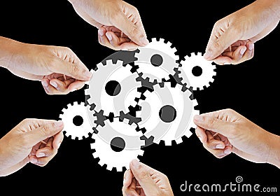 Teamwork works together to build a cog wheel gear system. Stock Photo