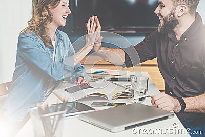 Teamwork, young designers are sitting at table in office and pick up finishing materials in catalog. Stock Photo