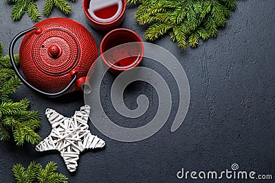 Teapot, cup, and fir tree branches create a cozy scene Stock Photo