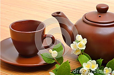 Teapot, teacup, saucer and jasmine flower twig on wood Stock Photo