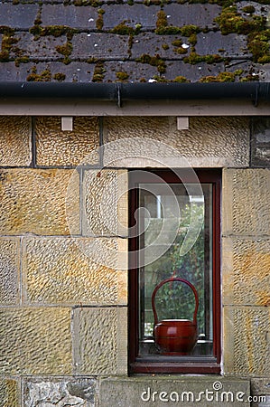 Teapot in window of house Stock Photo