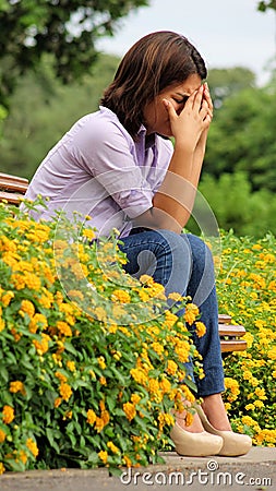 Tearful Female Sitting In Park Stock Photo