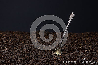 A teaspoon sticks out of a pile of loose tea Stock Photo