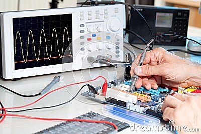 Tech tests electronic equipment Stock Photo