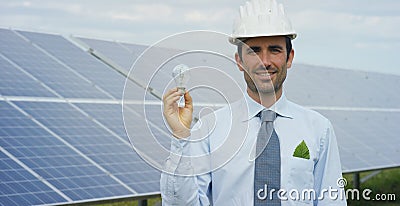 Technical expert in solar energy photovoltaic panels, remote control performs routine actions for system monitoring using clean, r Stock Photo