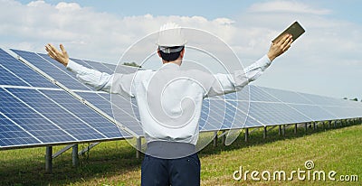 Technical expert in solar energy photovoltaic panels, remote control performs routine actions for system monitoring using clean, r Stock Photo