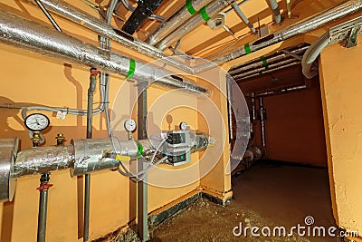 Technical pipes for sewerage in the basement of a building with pressure gauges. Distribution of pipes in the room Editorial Stock Photo