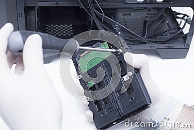 Technician assembling computer hardware parts. Hard drive being installed in a new computer Stock Photo