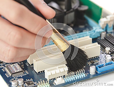 technician cleaning up the hardware of computer using brush Stock Photo