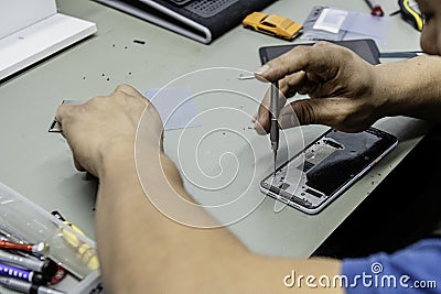 A technician disassembling the inside of a telephone on his workshop table Stock Photo